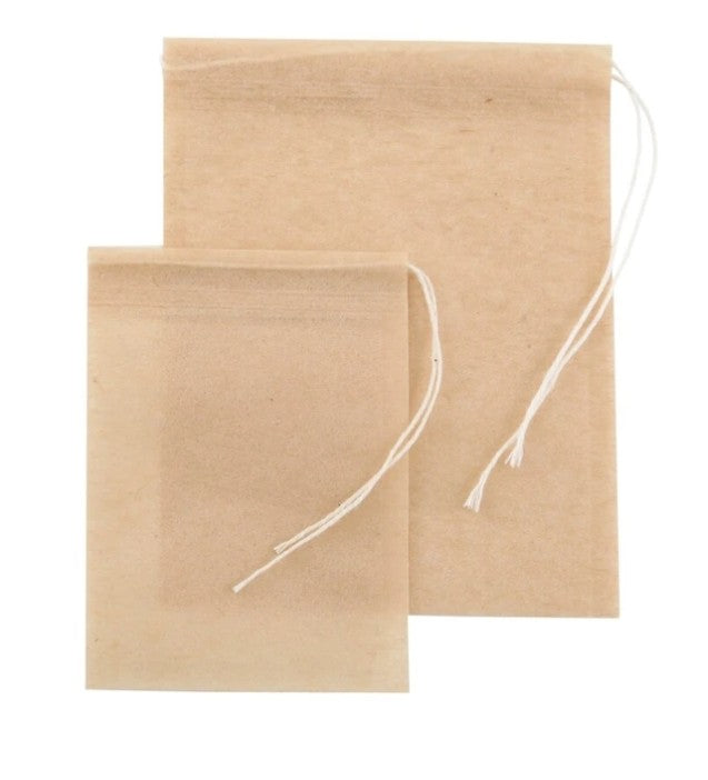 Two unbleached drawstring self-fill tea bags shown together